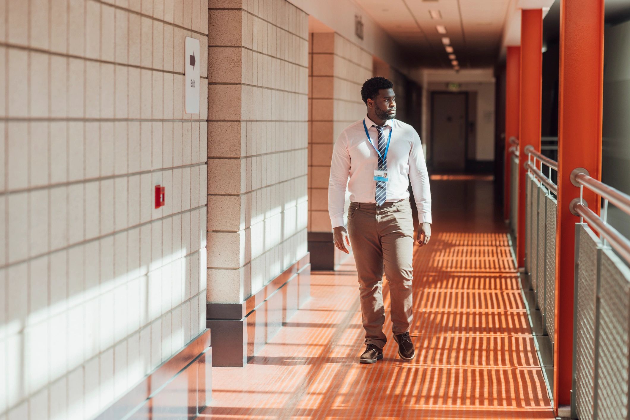 Speaker walking thoughtfully in a hallway