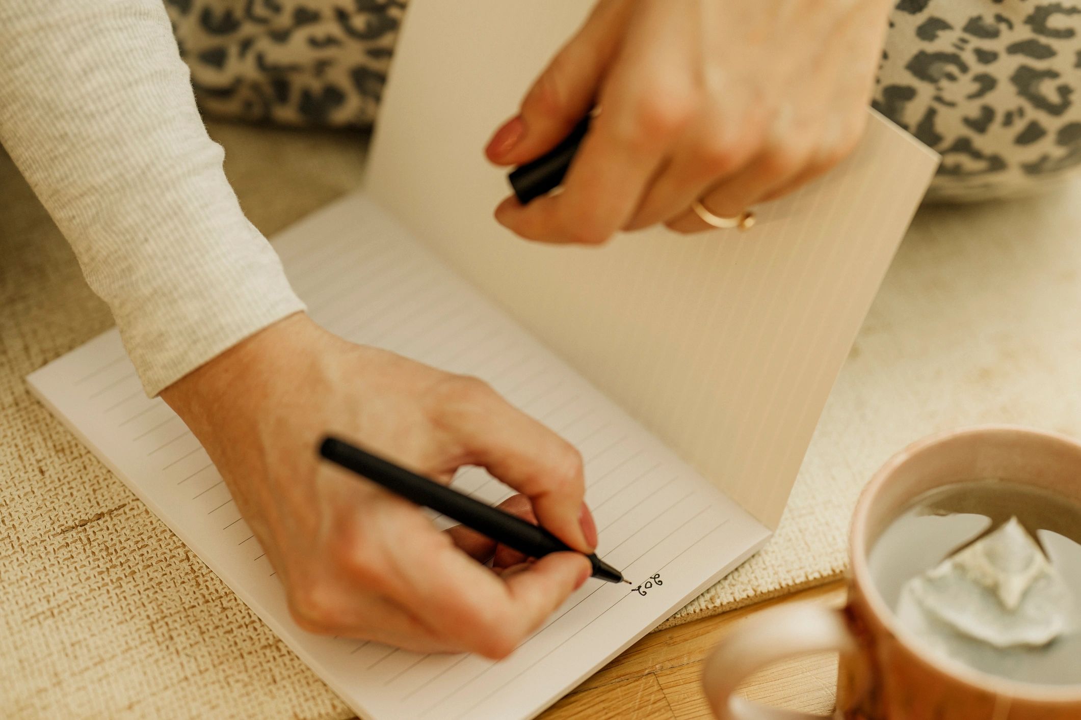 Hands writing in a notebook