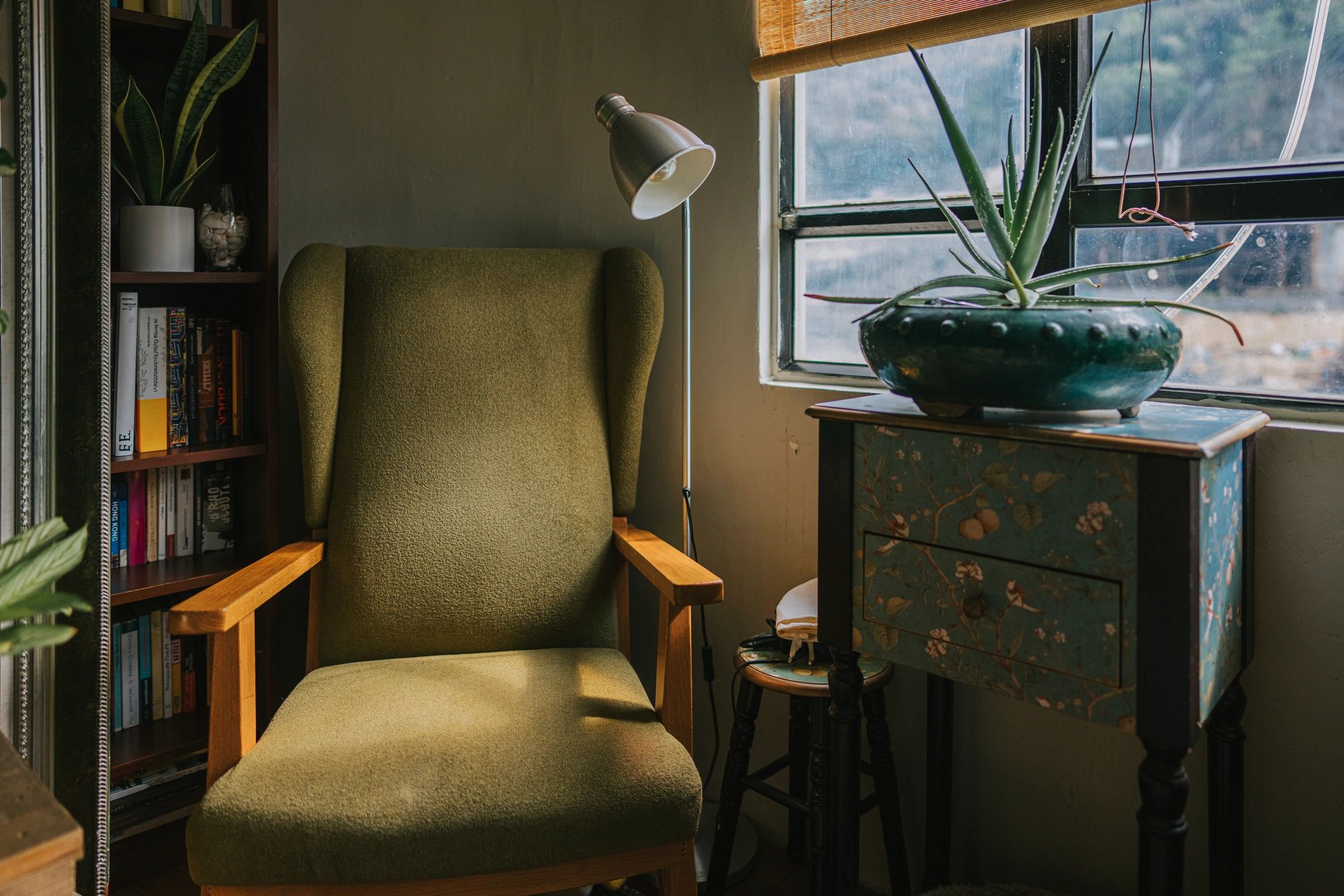 Empty chair beside a bookshelf in soft window light